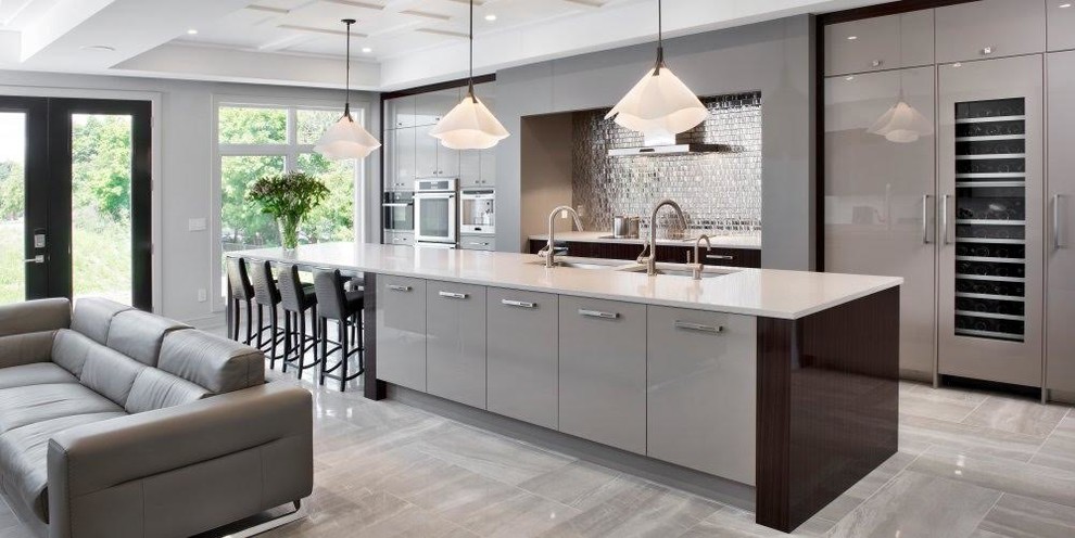 Large contemporary galley open plan kitchen in Miami with an undermount sink, flat-panel cabinets, grey cabinets, solid surface benchtops, metal splashback, panelled appliances, porcelain floors, with island and grey floor.