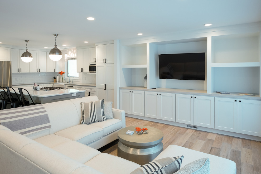 Design ideas for a mid-sized beach style formal open concept living room in Grand Rapids with white walls, light hardwood floors and a wall-mounted tv.