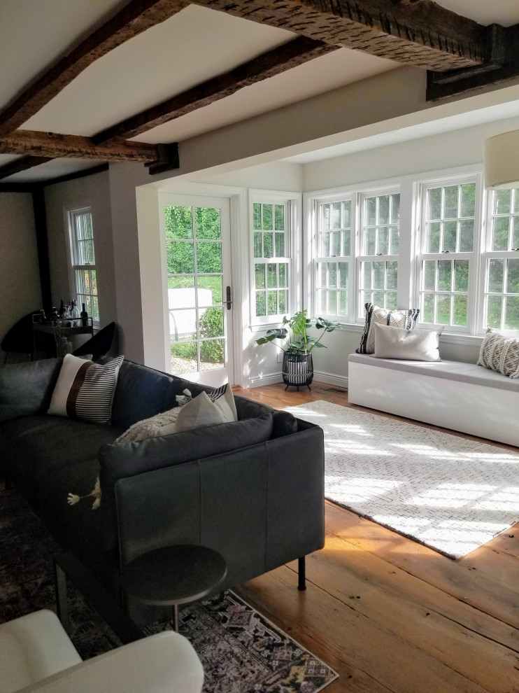 Photo of a small sunroom in New York with medium hardwood floors and brown floor.