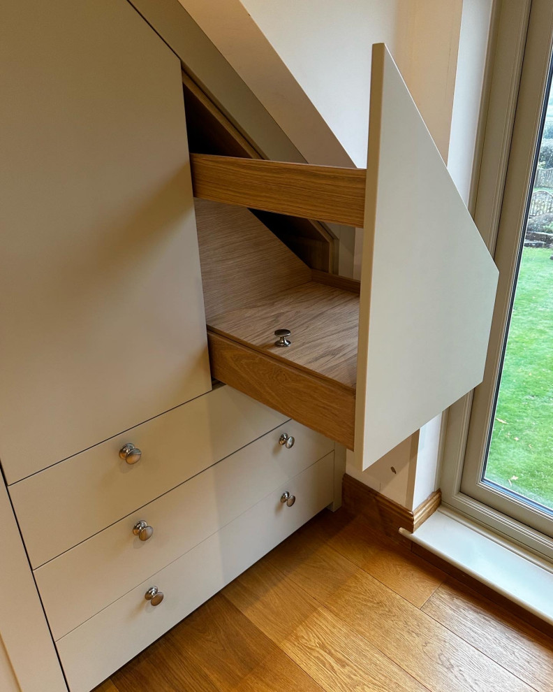 Inspiration for a large traditional gender neutral built-in wardrobe in Sussex with shaker cabinets and light wood cabinets.