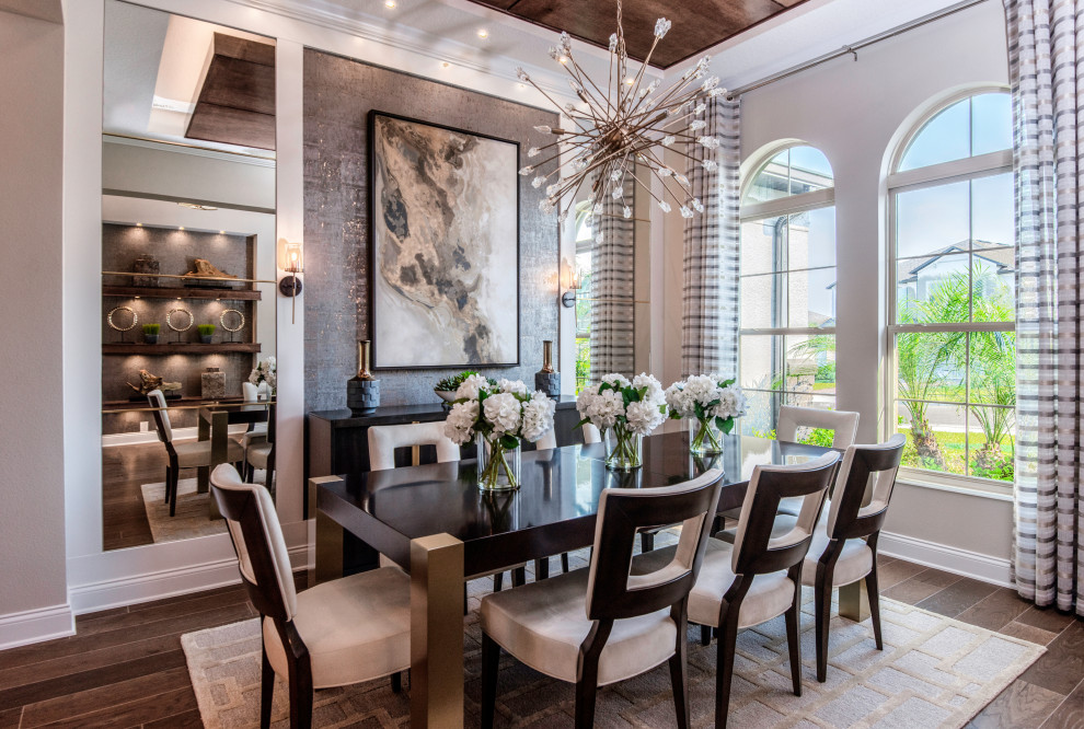 This is an example of a transitional separate dining room in Orlando with beige walls, medium hardwood floors, no fireplace, brown floor and wood.