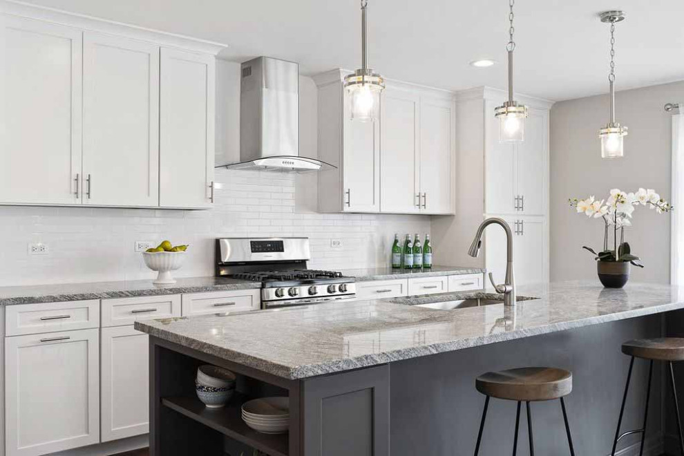 Inspiration for a mid-sized contemporary galley eat-in kitchen in Chicago with an undermount sink, flat-panel cabinets, white cabinets, granite benchtops, white splashback, subway tile splashback, stainless steel appliances, medium hardwood floors, with island, brown floor, grey benchtop and wallpaper.