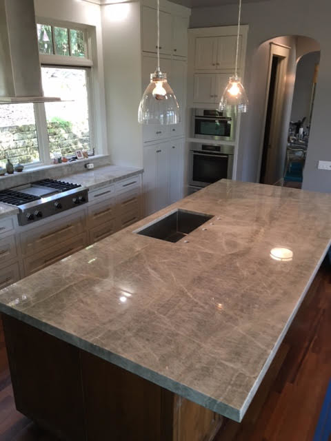 Mid-sized transitional l-shaped medium tone wood floor and gray floor kitchen photo in Austin with recessed-panel cabinets, white cabinets, an island, a double-bowl sink, marble countertops, stainless steel appliances and gray countertops