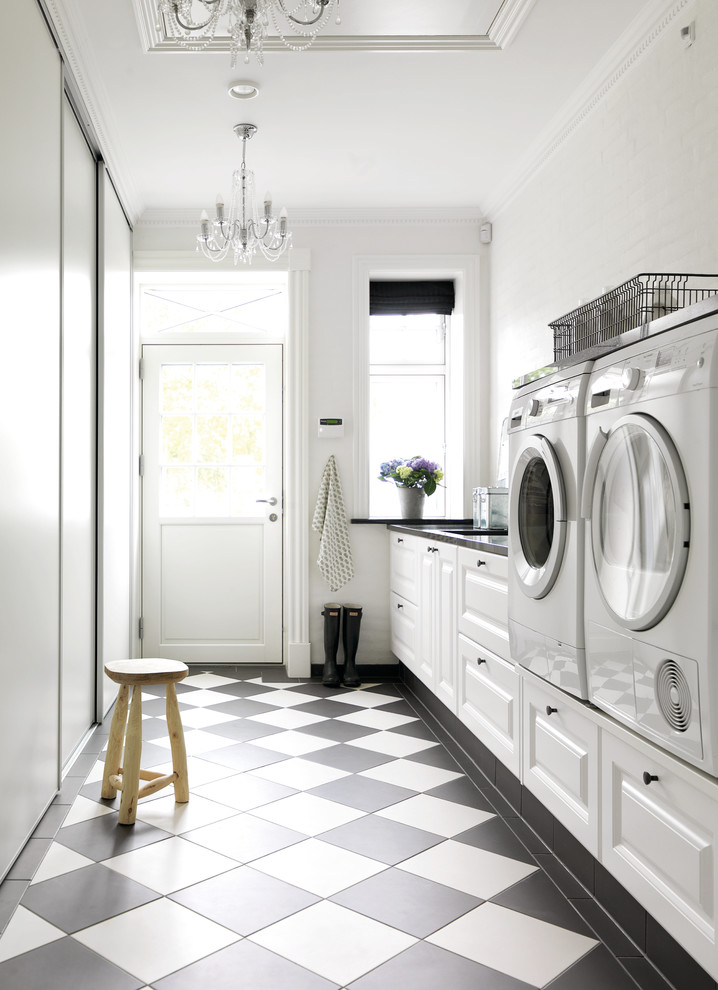 Design ideas for a mid-sized country single-wall dedicated laundry room with raised-panel cabinets, white cabinets, white walls, linoleum floors, a side-by-side washer and dryer and multi-coloured floor.
