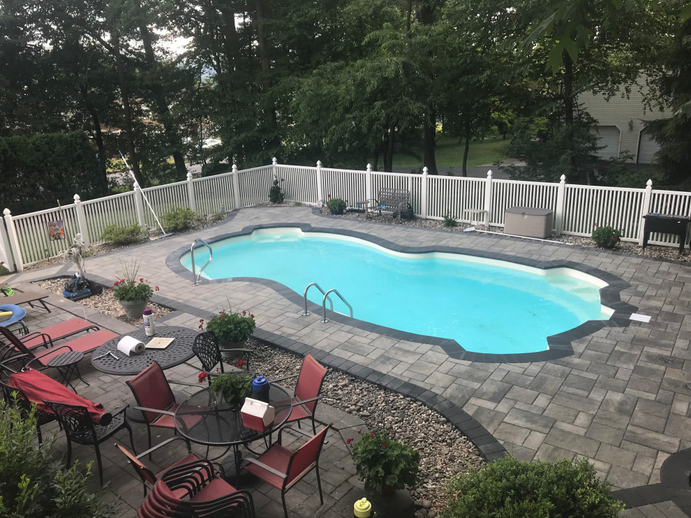 Mid-sized transitional concrete paver pool photo