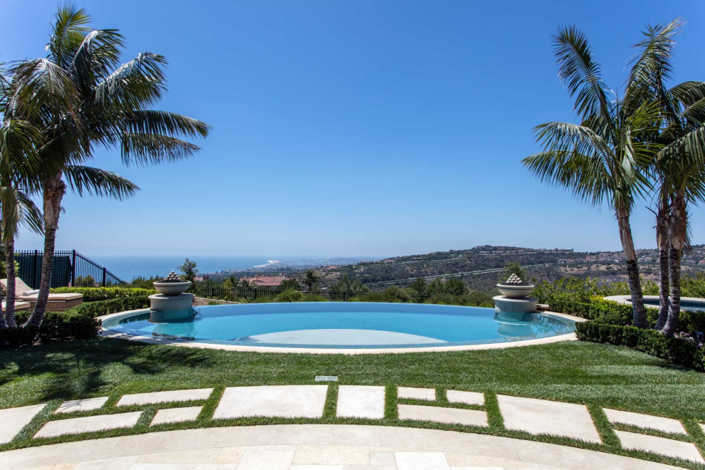 Mid-sized tuscan backyard stamped concrete and custom-shaped infinity pool house photo in Orange County