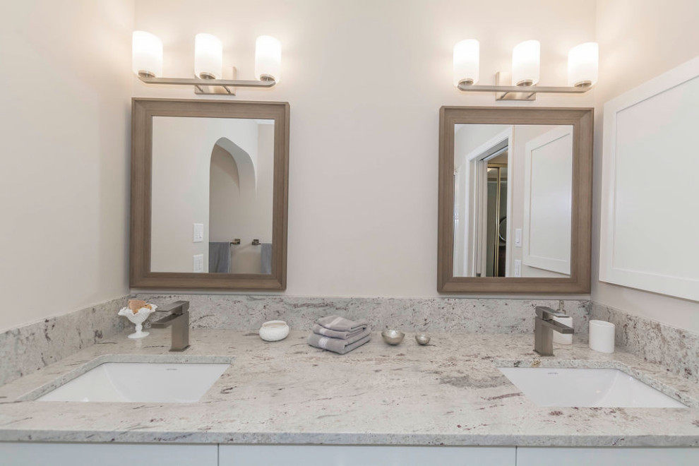 Drop-in bathtub - small transitional master vinyl floor, multicolored floor and double-sink drop-in bathtub idea in Edmonton with shaker cabinets, white cabinets, a two-piece toilet, beige walls, an undermount sink, granite countertops, gray countertops and a built-in vanity