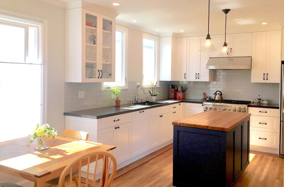 Photo of an eclectic eat-in kitchen in San Francisco with shaker cabinets, white cabinets, quartz benchtops, grey splashback, ceramic splashback, light hardwood floors and with island.