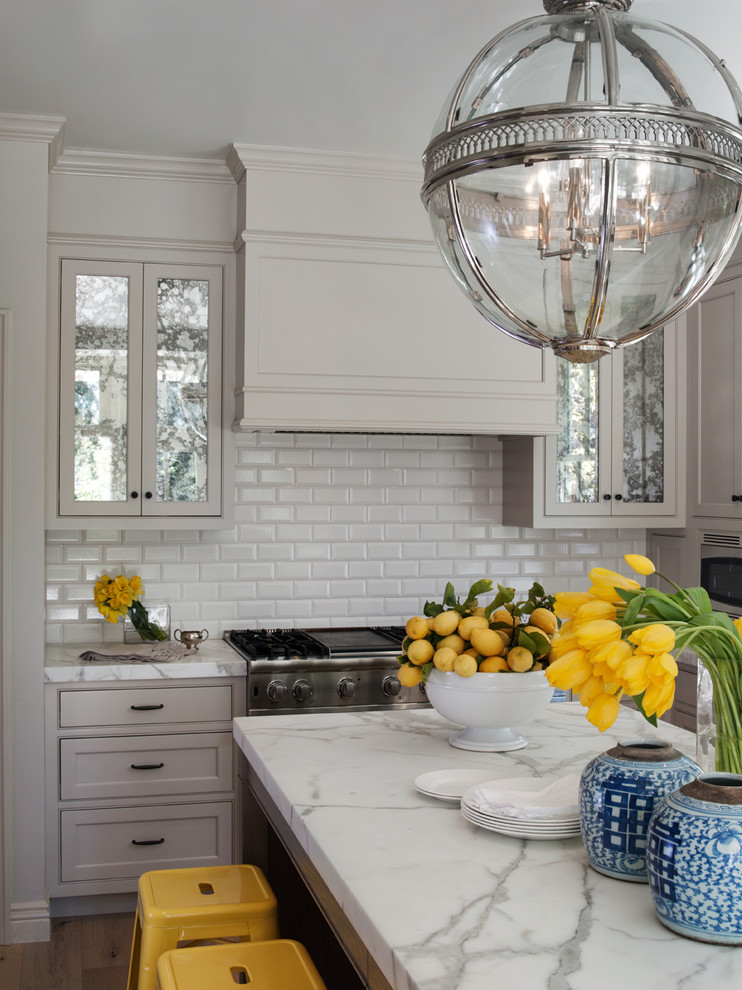 This is an example of a traditional kitchen in San Francisco with marble benchtops, beaded inset cabinets, grey cabinets, white splashback and subway tile splashback.