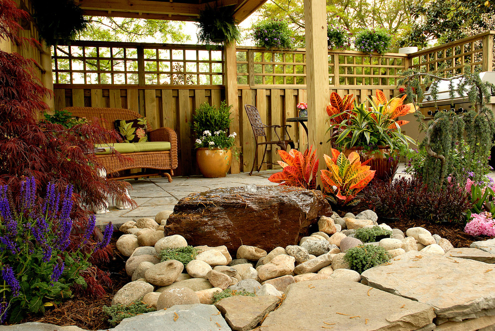 Design ideas for a mid-sized country backyard full sun garden for spring in Other with natural stone pavers and a water feature.