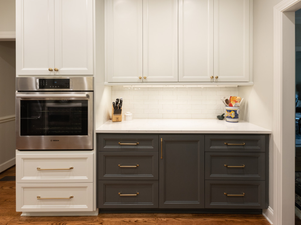 Inspiration for a mid-sized transitional galley medium tone wood floor and brown floor kitchen pantry remodel with an undermount sink, shaker cabinets, gray cabinets, granite countertops, white backsplash, ceramic backsplash, stainless steel appliances, no island and white countertops