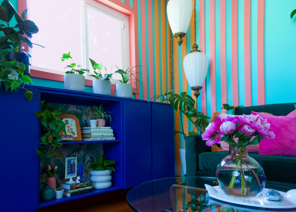 Idée de décoration pour un salon ethnique de taille moyenne et fermé avec un mur bleu, un sol en bois brun, un téléviseur fixé au mur, du lambris et un sol rouge.