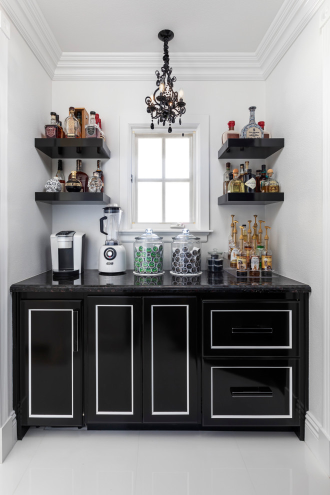 Inspiration for a small transitional single-wall home bar in Orange County with recessed-panel cabinets, black cabinets, quartzite benchtops, porcelain floors, white floor and black benchtop.