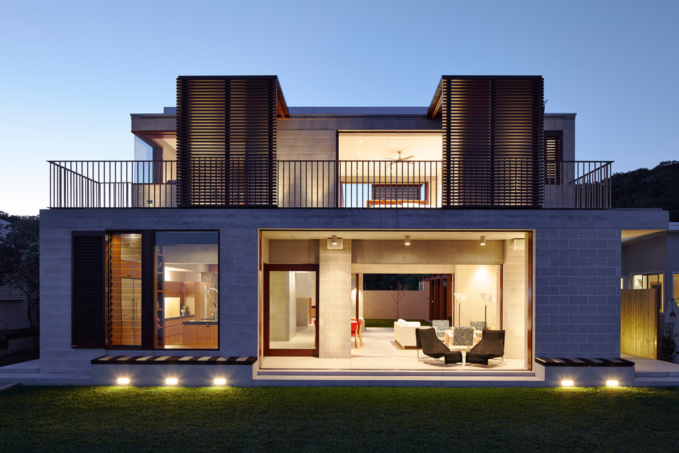 Mid-sized contemporary two-storey concrete grey house exterior in Sydney with a flat roof and a mixed roof.