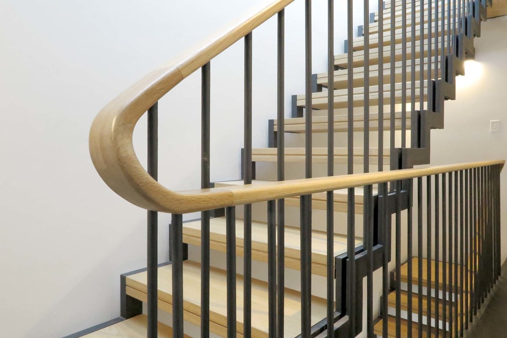 This is an example of a mid-sized contemporary wood straight staircase in Sydney with open risers and metal railing.
