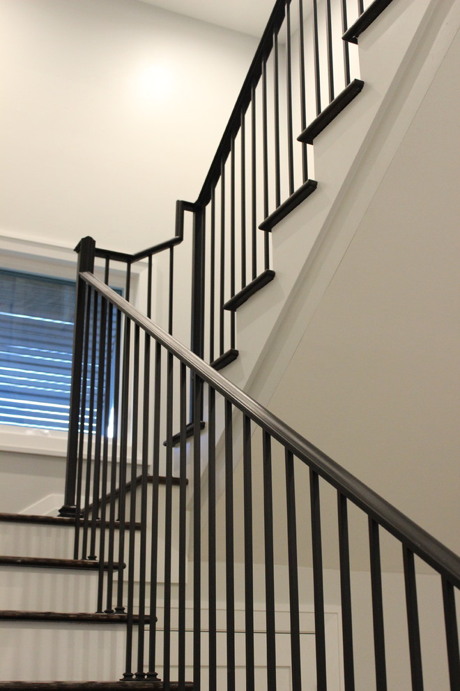 Design ideas for a large transitional wood staircase in Other with wood risers and metal railing.