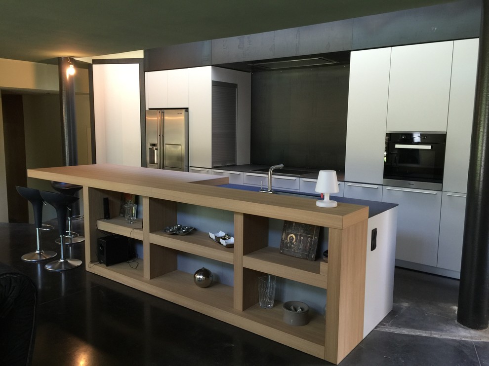 Photo of a large modern galley open plan kitchen in Other with white cabinets, wood benchtops, concrete floors, with island, grey floor and beige benchtop.