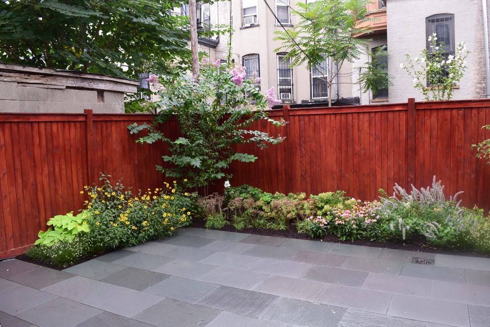 Inspiration for a small modern backyard full sun formal garden for summer in New York with natural stone pavers.