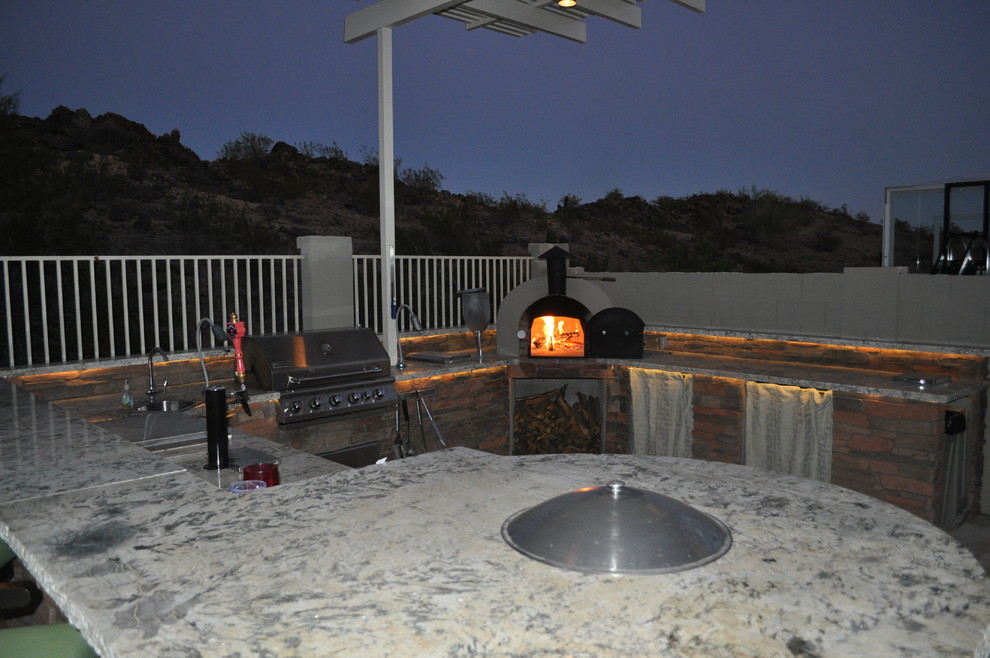 Mid-sized minimalist backyard stone home design photo in Phoenix with a pergola