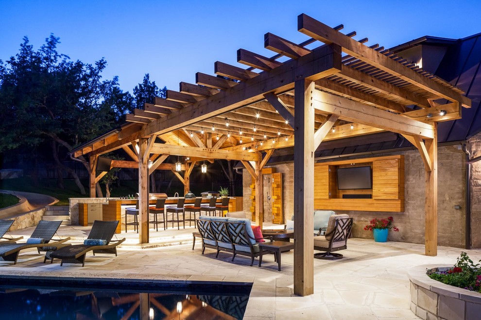 Expansive transitional backyard patio in Austin with an outdoor kitchen and a roof extension.