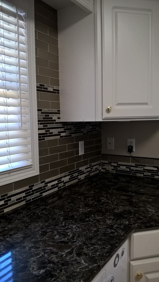 Kitchen - transitional kitchen idea with a double-bowl sink, raised-panel cabinets, white cabinets, granite countertops, multicolored backsplash, glass tile backsplash and stainless steel appliances