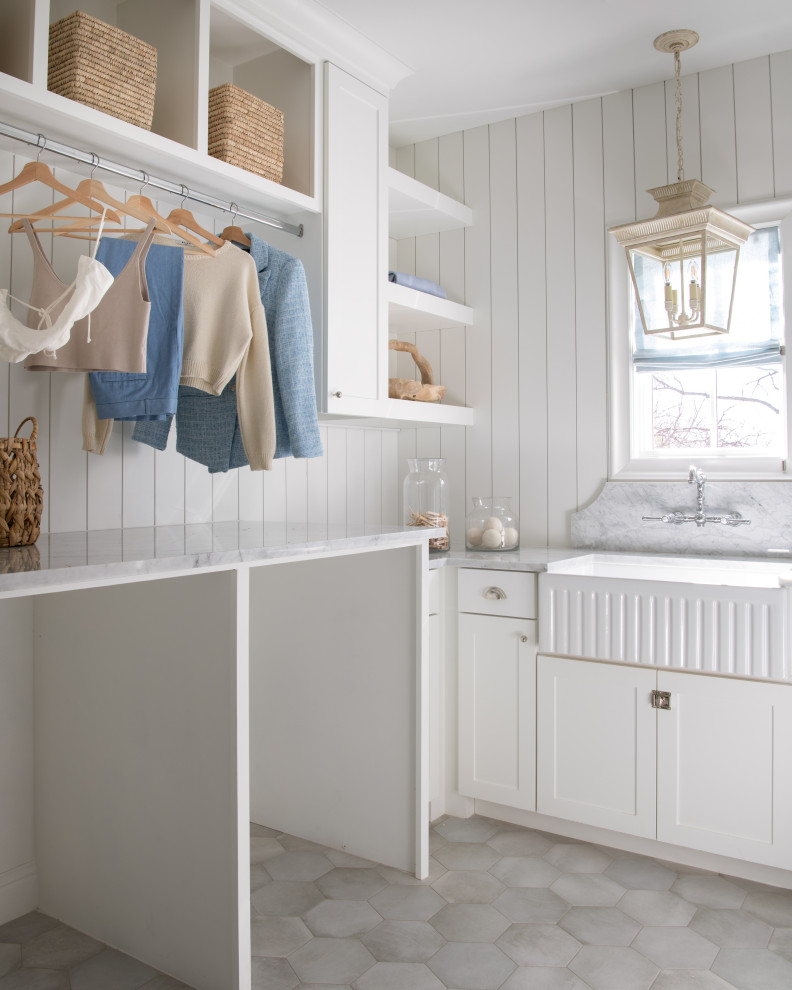 Design ideas for a large transitional l-shaped dedicated laundry room in Dallas with a farmhouse sink, shaker cabinets, white cabinets, marble benchtops, white splashback, shiplap splashback, white walls, porcelain floors, a side-by-side washer and dryer, grey floor and white benchtop.