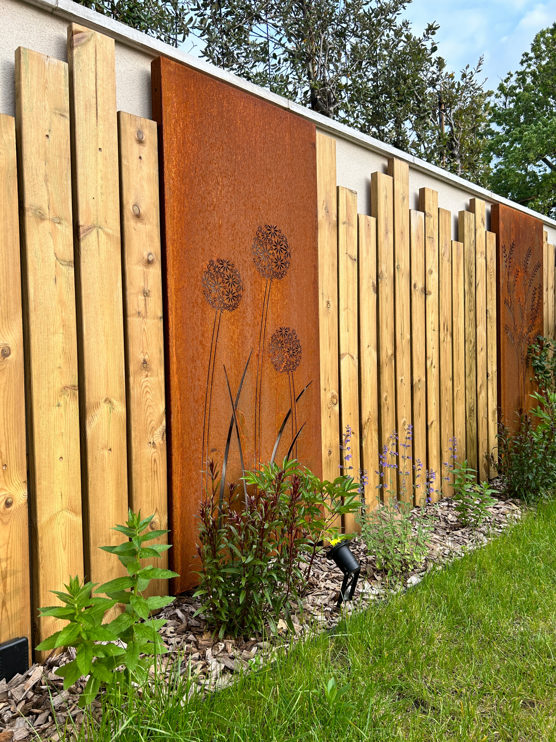 Aménagement du jardin avec des palissades en bois et des arbres palissés.