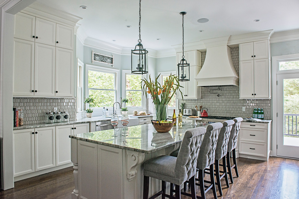Inspiration for a mid-sized l-shaped eat-in kitchen in Nashville with a farmhouse sink, beaded inset cabinets, white cabinets, quartzite benchtops, grey splashback, mosaic tile splashback, stainless steel appliances, medium hardwood floors, with island, brown floor and grey benchtop.