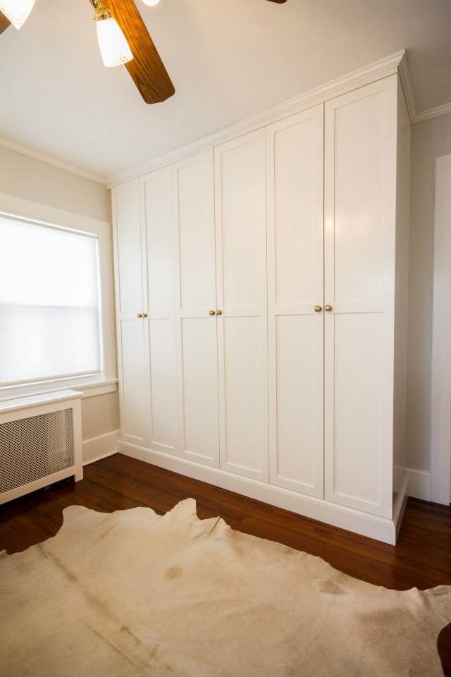 Mid-sized modern gender-neutral storage and wardrobe in New York with flat-panel cabinets and light wood cabinets.