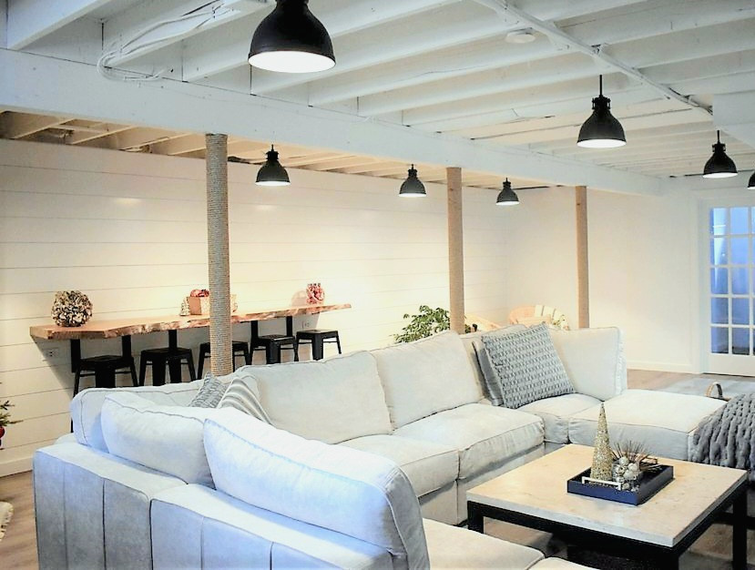 Cette image montre un sous-sol traditionnel avec un mur blanc, un sol en vinyl, un sol marron, poutres apparentes et du lambris de bois.