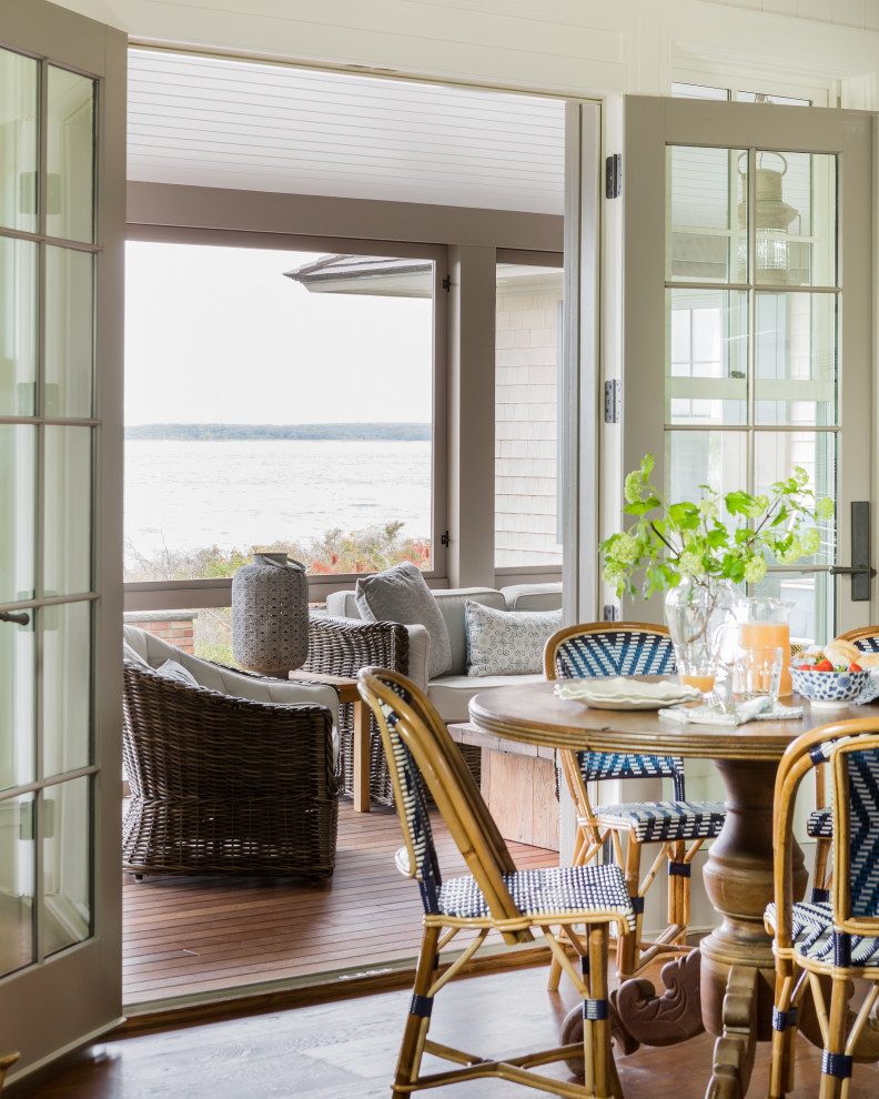 Example of a large beach style backyard dining room design in Boston with a fireplace, decking and a roof extension
