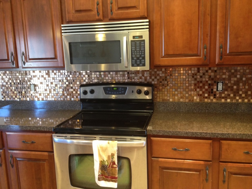 Example of a transitional kitchen design in Chicago with raised-panel cabinets, dark wood cabinets, quartz countertops, multicolored backsplash, mosaic tile backsplash and stainless steel appliances