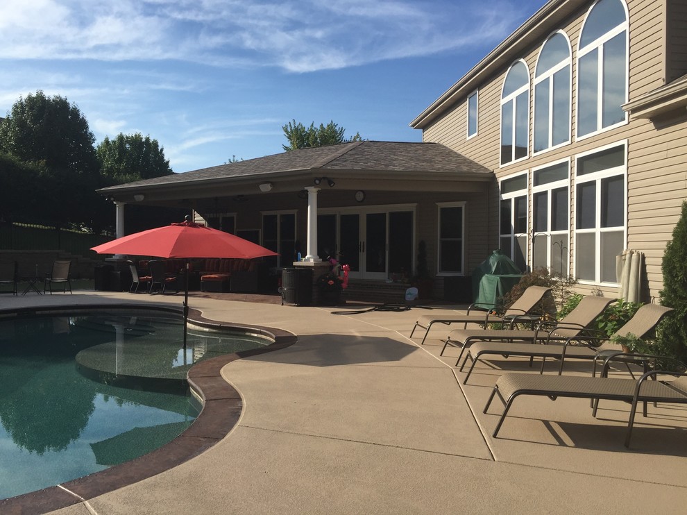 Pool - mid-sized traditional backyard stamped concrete and custom-shaped natural pool idea in St Louis