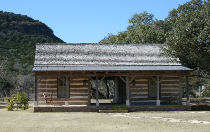 Photo of a country one-storey grey exterior in Austin with wood siding and a hip roof.
