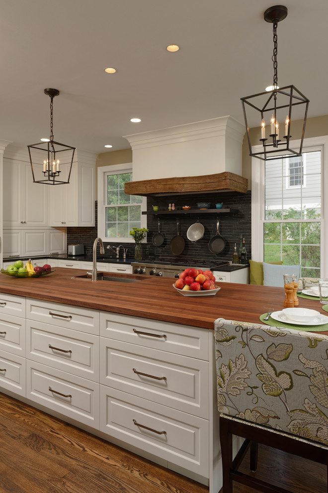 Inspiration for a large traditional l-shaped eat-in kitchen in DC Metro with an undermount sink, beaded inset cabinets, white cabinets, wood benchtops, grey splashback, mosaic tile splashback, panelled appliances, medium hardwood floors and with island.