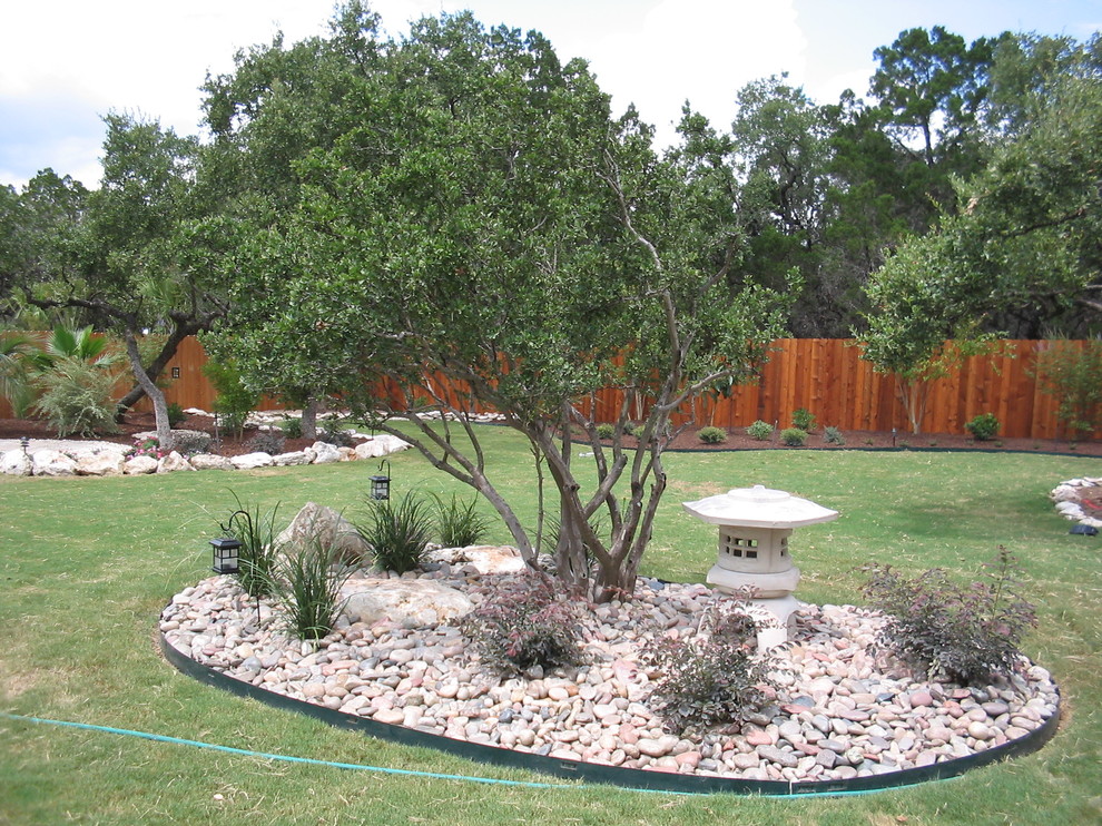 Inspiration for a mid-sized traditional backyard full sun xeriscape for summer in Austin with concrete pavers and a water feature.