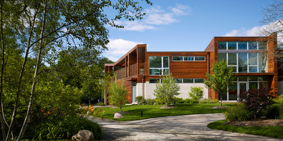 Expansive contemporary two-storey multi-coloured house exterior in Chicago with wood siding and a flat roof.