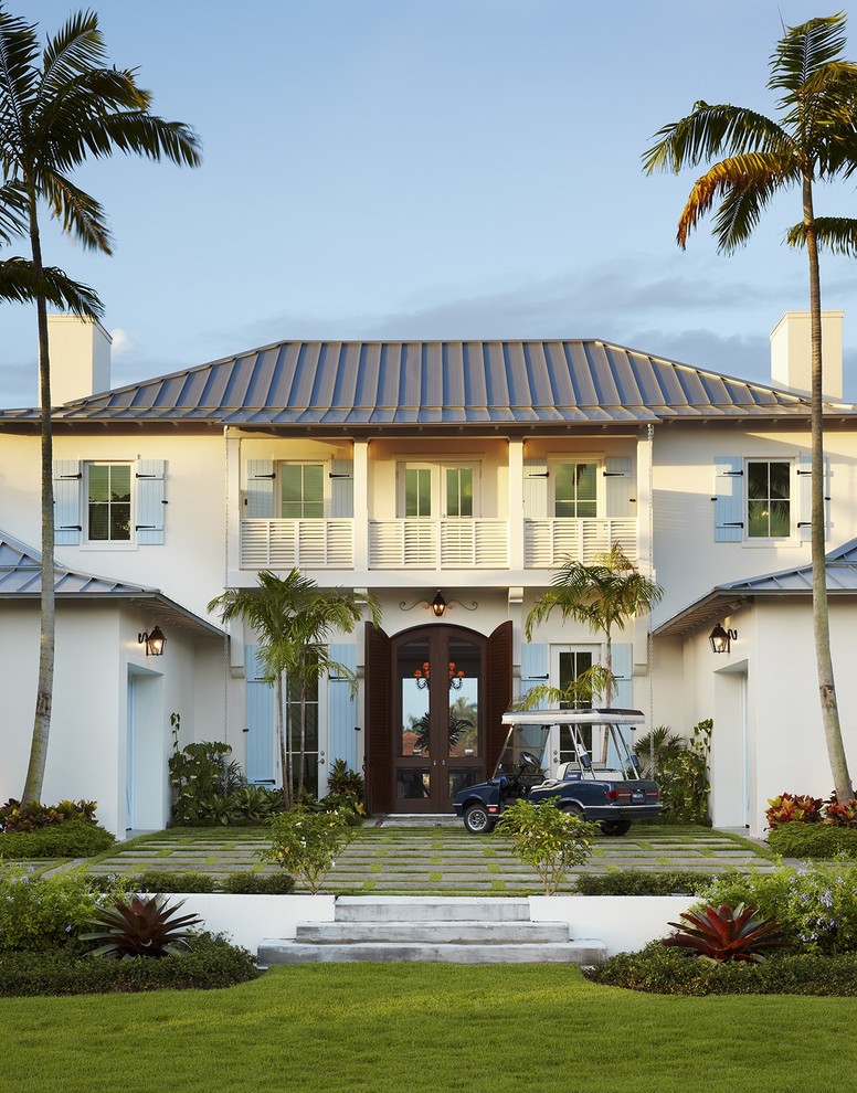 Photo of a large tropical two-storey exterior in Miami with a hip roof.