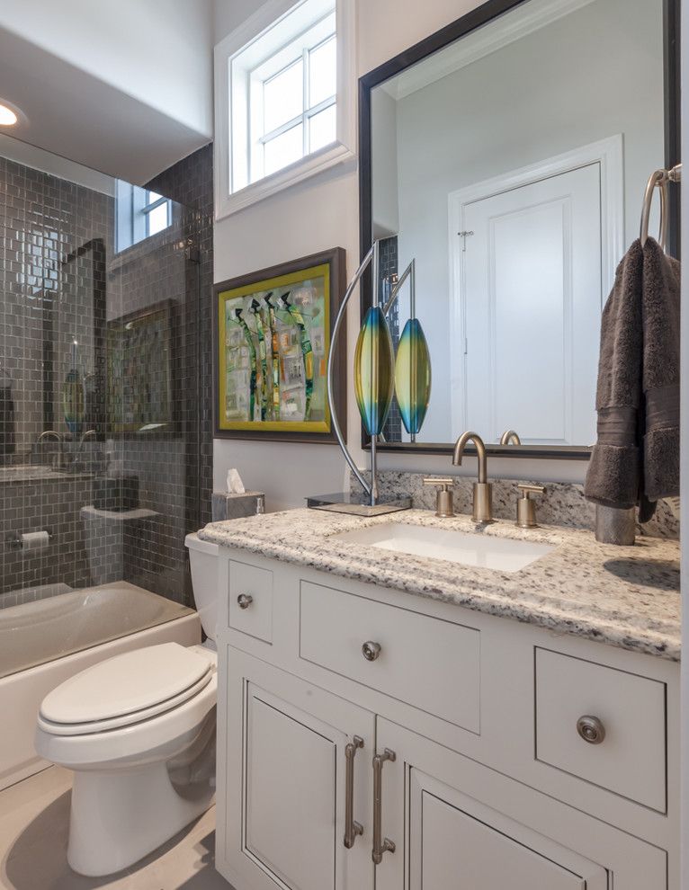Photo of a small traditional 3/4 bathroom in Houston with flat-panel cabinets, red cabinets, a drop-in tub, an alcove shower, a one-piece toilet, black and white tile, ceramic tile, grey walls, medium hardwood floors, a drop-in sink and granite benchtops.