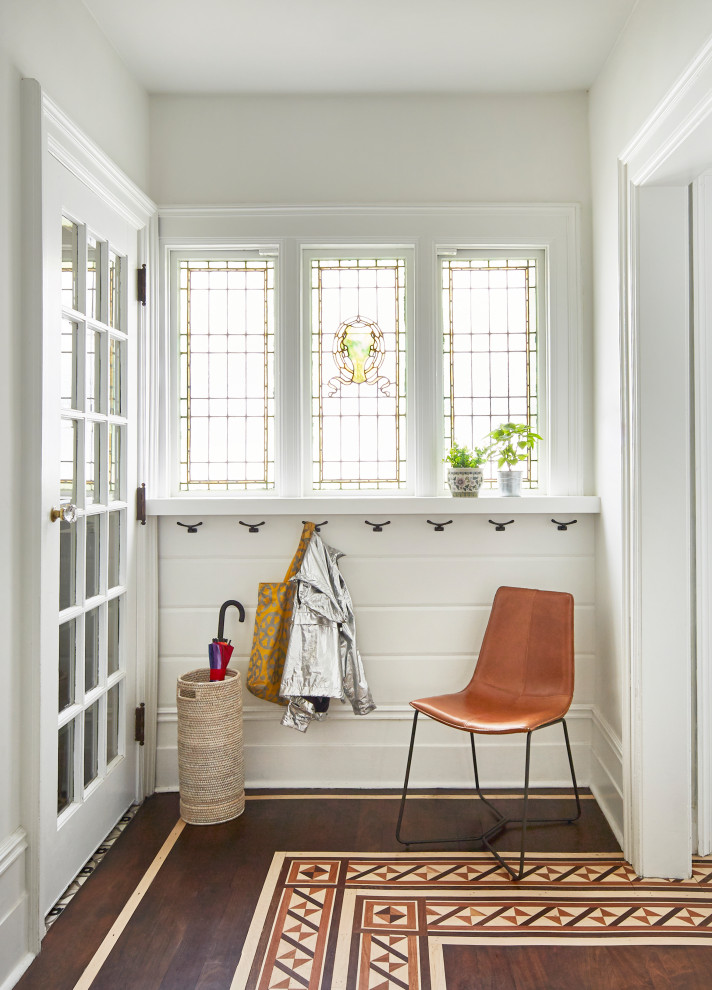 Photo of a medium sized eclectic entrance in New York with white walls, dark hardwood flooring and tongue and groove walls.