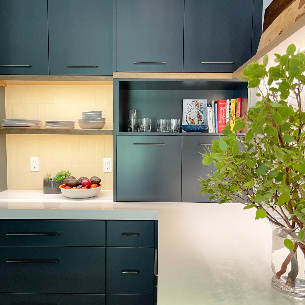 Esempio di una cucina moderna di medie dimensioni con lavello sottopiano, ante lisce, ante blu, top in superficie solida, paraspruzzi beige, paraspruzzi in mattoni, elettrodomestici da incasso e top bianco