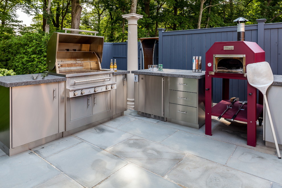 Inspiration for a mid-sized contemporary backyard patio in New York with an outdoor kitchen, natural stone pavers and a pergola.