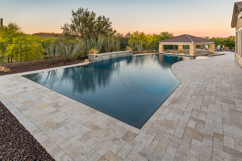 Example of a large backyard stone and custom-shaped hot tub design in Phoenix