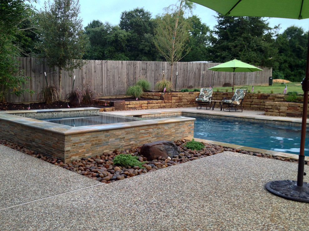 This is an example of a large country backyard custom-shaped pool in Houston with concrete slab.