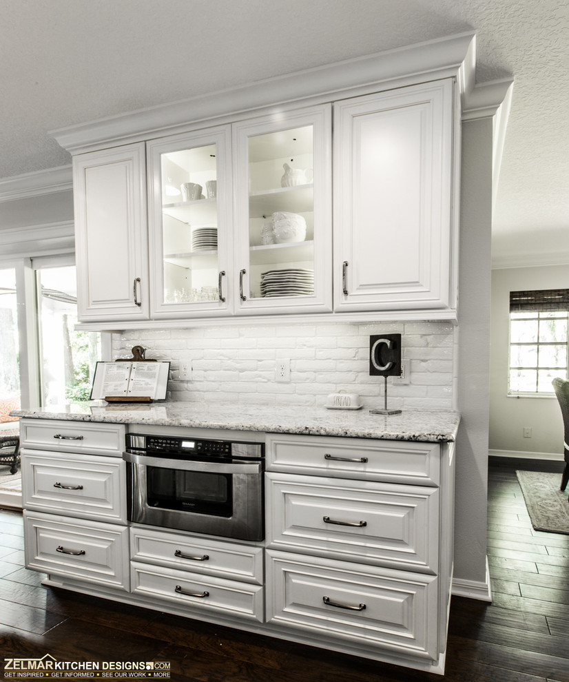 Large traditional u-shaped eat-in kitchen in Orlando with raised-panel cabinets, white cabinets and with island.