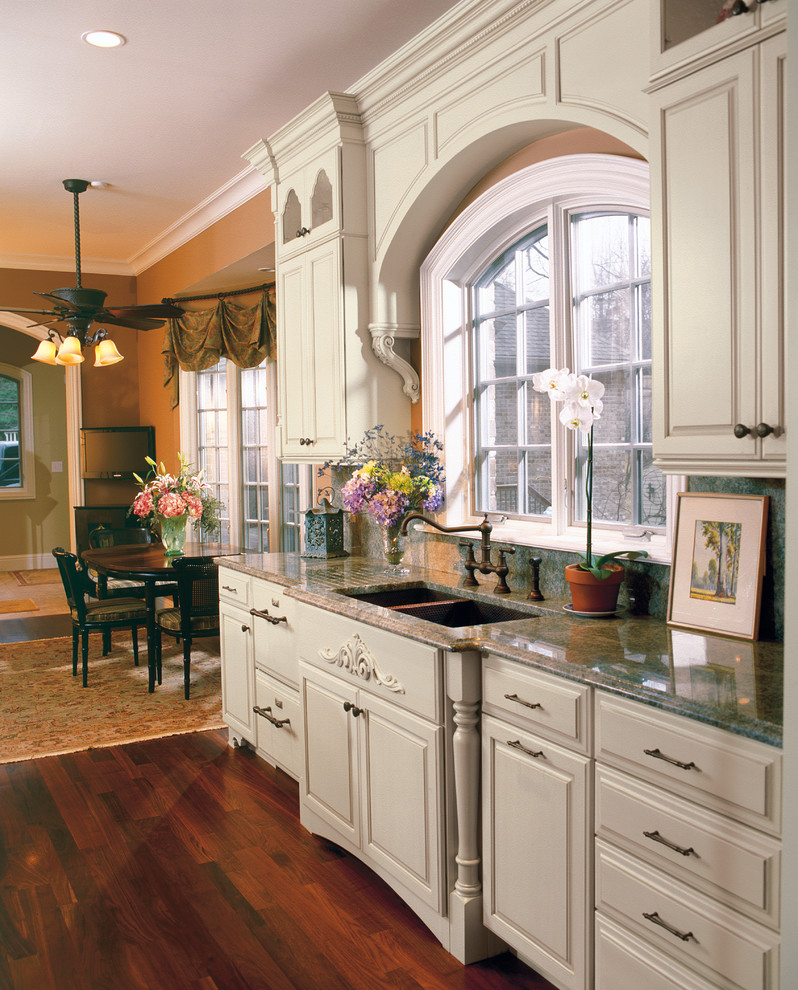 Photo of a traditional l-shaped open plan kitchen in Cleveland with a double-bowl sink, beaded inset cabinets, white cabinets, panelled appliances and brown floor.