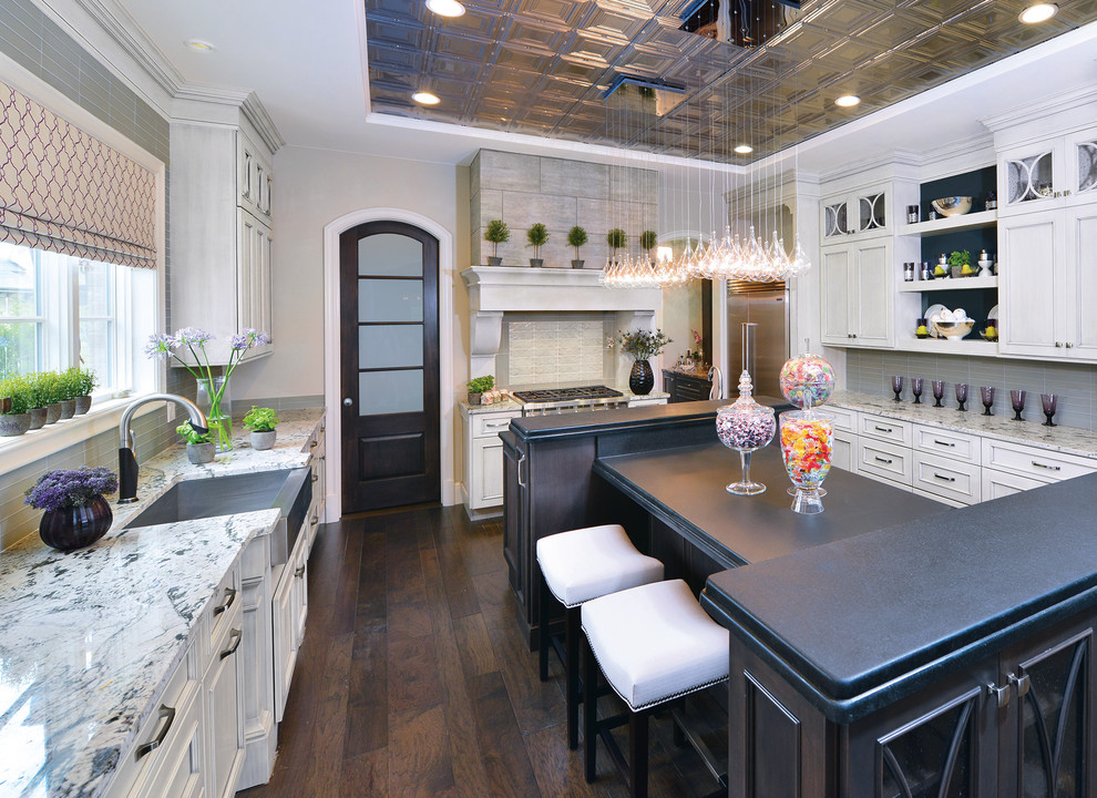 Design ideas for a large contemporary u-shaped separate kitchen in Detroit with a drop-in sink, raised-panel cabinets, white cabinets, grey splashback, glass tile splashback, stainless steel appliances, dark hardwood floors, quartzite benchtops, with island and brown floor.