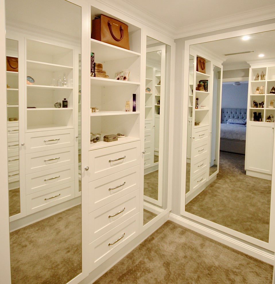 Design ideas for a large transitional women's walk-in wardrobe in Sydney with recessed-panel cabinets, white cabinets, medium hardwood floors and brown floor.