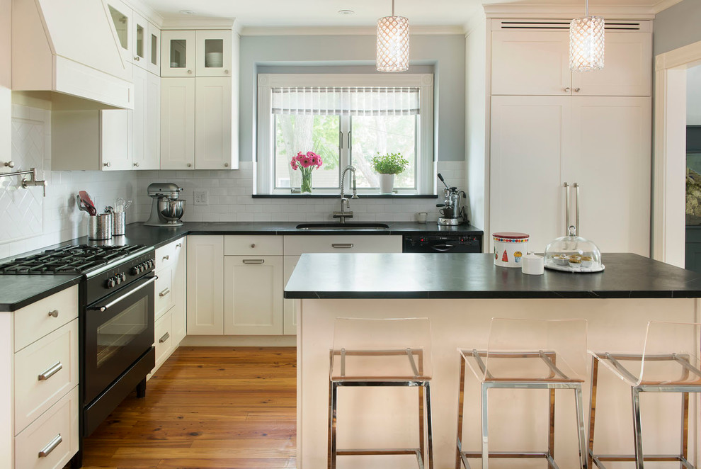 This is an example of a contemporary l-shaped kitchen in Boston with shaker cabinets, panelled appliances, soapstone benchtops, white splashback, subway tile splashback, an undermount sink, white cabinets and with island.