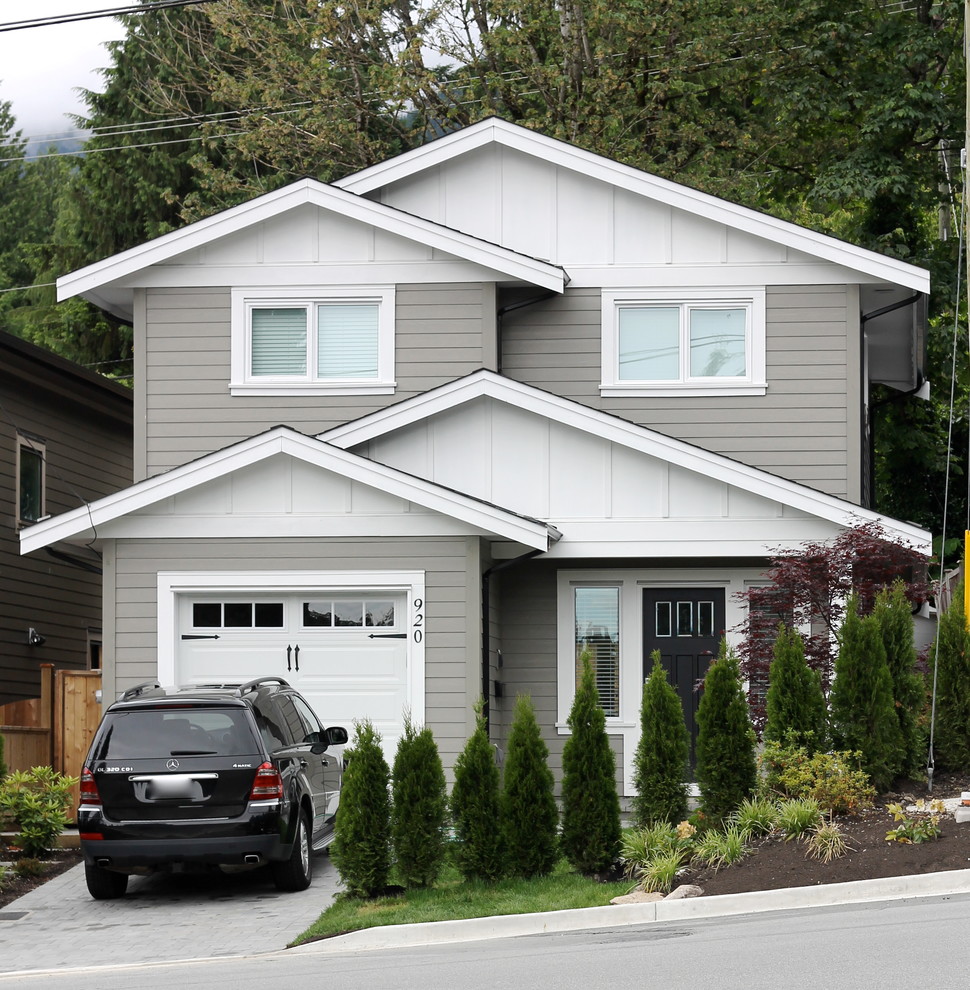 Photo of a mid-sized traditional three-storey grey exterior in Vancouver with a gable roof and vinyl siding.